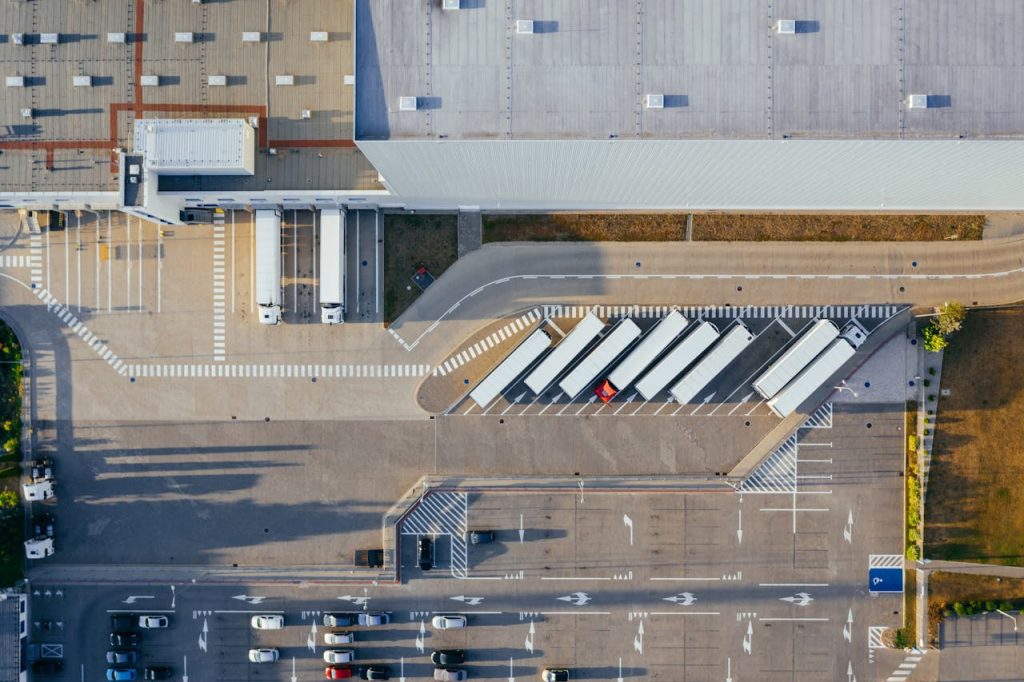 Drone shot of a logistics center with trucks and parking lot in Poznań, Poland.